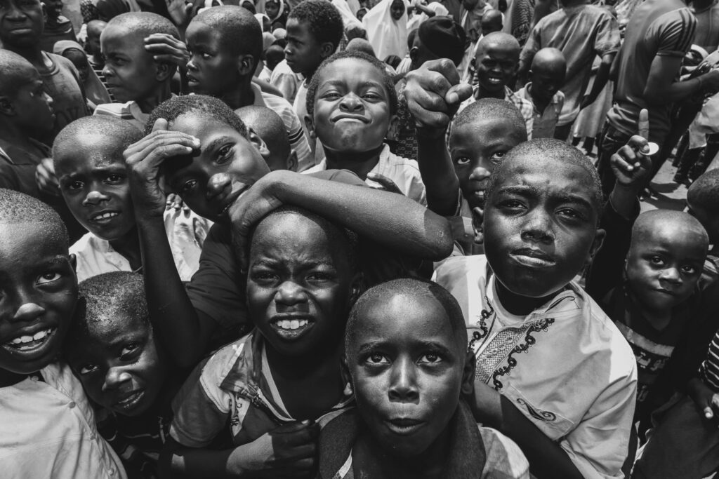Black and white photo capturing the lively expressions of children in Zanzibar City.