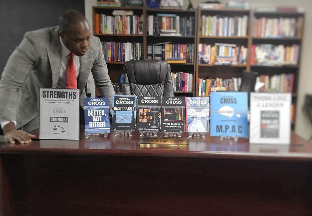 Dr. Richard A. Cross, Ed.D. in his office with books